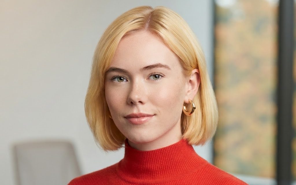 A smiling woman in a red turtleneck